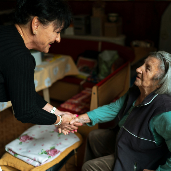 Caregiver familiare affaticato mentre assiste un anziano a domicilio