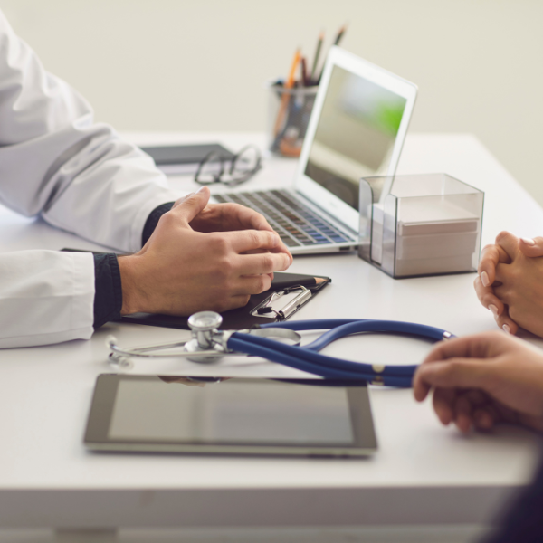 Medico di famiglia che prescrive l'Assistenza Domiciliare Integrata a un paziente anziano durante una visita a domicilio